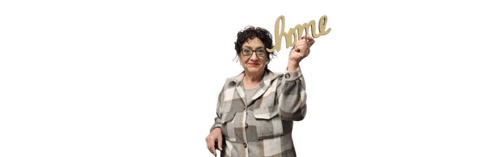 Sally from Crown Realty Services smiling and holding a wooden HOME sign, offering personalized real estate guidance.