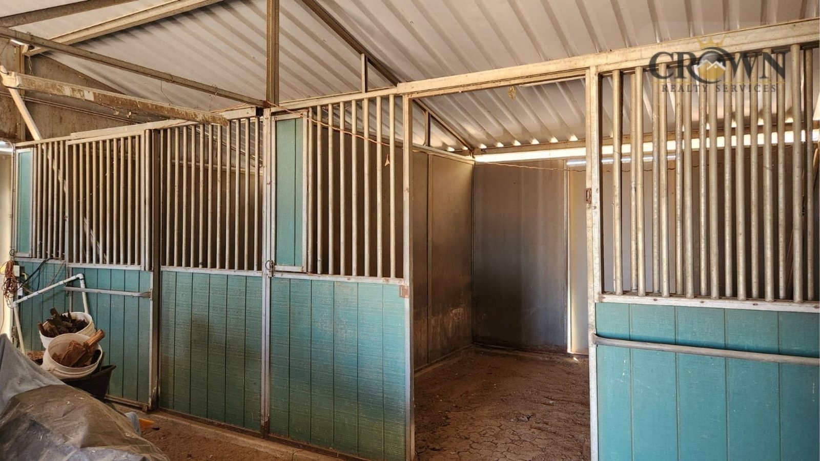 Covered metal horse corrals with protective sheet metal roofing on a ranch property in Phelan, CA.